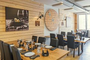 a restaurant with wooden walls and tables and chairs at Esplanade Hotel in Diekirch
