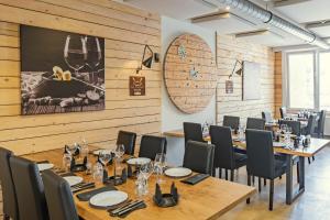ein Restaurant mit Holzwänden, Tischen und Stühlen in der Unterkunft Esplanade Hotel in Diekirch