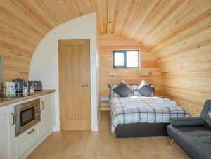 um quarto com uma cama num quarto com paredes de madeira em Caban Cariad em Holyhead
