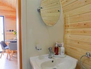 a bathroom with a sink and a mirror at Caban Cariad in Holyhead
