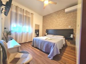 een slaapkamer met een bed en een bakstenen muur bij Rossi&Nero Resort - Ristorante, B&B, Piscina, Sauna 