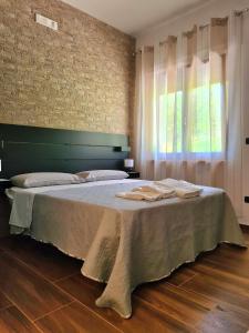 a bedroom with a bed with towels on it at Rossi&Nero Resort - Ristorante, B&B, Piscina, Sauna 