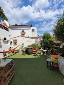 un patio trasero con un patio verde con mesas y sillas en Can Cocollona, en Girona