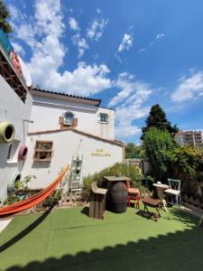 einen Garten mit einer Hängematte vor einem Gebäude in der Unterkunft Can Cocollona in Girona