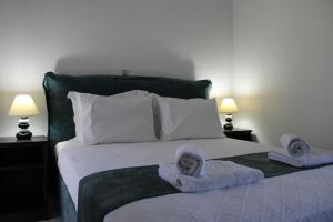 een slaapkamer met een bed met handdoeken erop bij Drebos Apartments in Lazaráta
