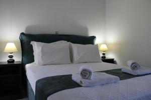 a bedroom with a bed with towels on it at Drebos Apartments in Lazaráta