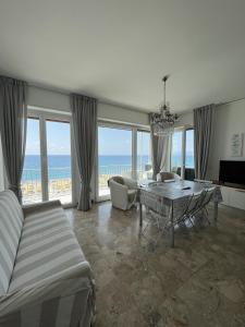 un soggiorno con letto, tavolo e vista sull'oceano di Appartamento Direttamente sul Mare a Finale Ligure