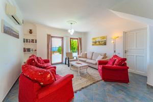a living room with two red chairs and a couch at Pier Rooms & Pansiyon in Kalkan
