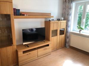 a large wooden entertainment center with a flat screen tv at FeWo "Biela", gemütlich, zentral, ruhig, Terrasse, Sandstein-Ferien, Familienfreundl in Königstein an der Elbe