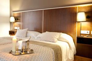 a hotel room with a large bed with candles on it at Hotel Plaza Manjón in Villanueva del Arzobispo