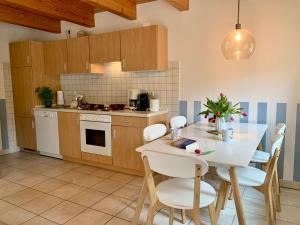 a kitchen with a white table and chairs in a kitchen at Ferienwohnung 3 im Böhler Haubarg in Sankt Peter-Ording