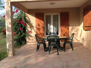 een patio met een tafel en stoelen bij Residence Cucunacciu in Cargèse