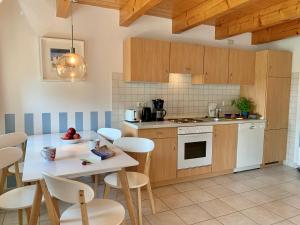 a kitchen with wooden cabinets and a table and chairs at Ferienwohnung 4 im Böhler Haubarg in Sankt Peter-Ording