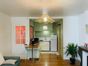 une cuisine avec des murs verts, une table et un lustre dans l'établissement Appartement Citadelle-Victor-Hugo, à Besançon