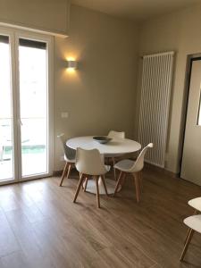 una sala da pranzo con tavolo e sedie bianchi di Hotel Ariston & Apartments a Varazze