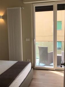 een slaapkamer met een bed en een glazen schuifdeur bij Hotel Ariston & Apartments in Varazze