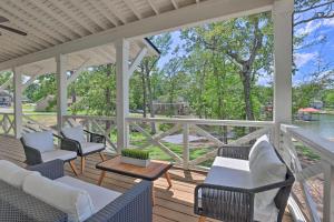 a porch with chairs and tables and a view of the water at Luxe Lakefront Getaway with Porch and Water View! in Dadeville