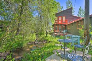a house with a table and chairs in the yard at Picturesque Creekside Cabin - Hike and Fish! in Cuchara