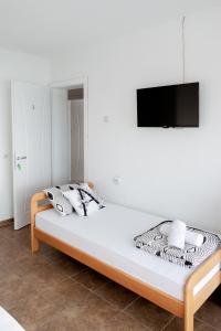 a bedroom with a bed with a tv on the wall at Villa Lazar in Trpejca