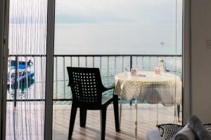a table and chair on a balcony with a view of the ocean at Villa Lazar in Trpejca