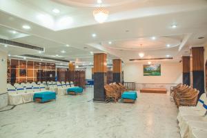 a banquet hall with white tables and blue chairs at Hotel Priya Palace in Guwahati