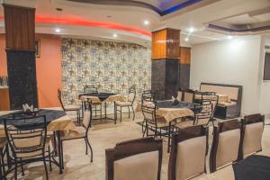 a restaurant with tables and chairs in a room at Hotel Priya Palace in Guwahati +29 photos