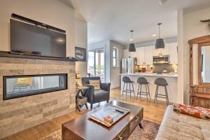 a living room with a fireplace and a tv at Grand Lake Condo with Balcony and Mountain Views in Grand Lake