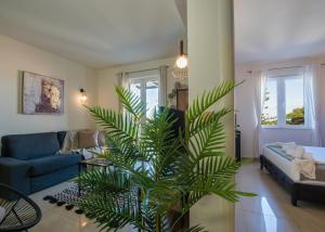 salon z niebieską kanapą i palmą w obiekcie Artdeco Luxury Suites w mieście Korakiaí +37 zdjęć