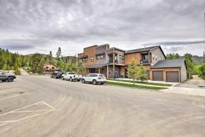 a house with cars parked on the side of a street at Grand Lake Condo with Balcony and Mountain Views in Grand Lake