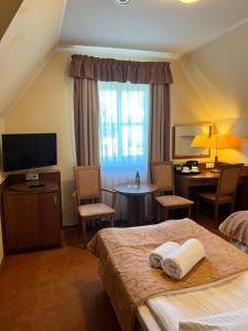 a hotel room with two beds and a desk at Willa Katrin in Mikołajki