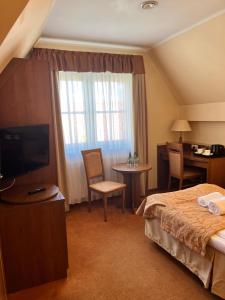 a hotel room with a bed and a television at Willa Katrin in Mikołajki +23 photos