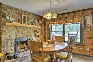 a dining room with a table and a fireplace at Buckhead Cabin with Fireplaces and Private Pool! in Eatonton 