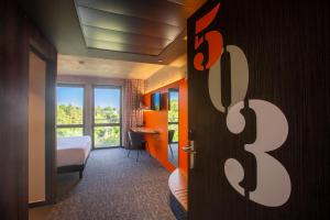 a hotel room with a bed and a window at Lorraine H&ocirc;tel Nancy Ouest - Laxou in Nancy