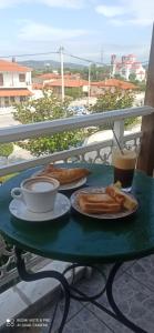 uma mesa verde com uma chávena de café e pão em Hotel-Apartments La Strada em Tycherón