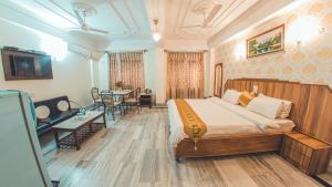 a hotel room with a bed and a dining room at Hotel Priya Palace in Guwahati