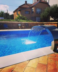 a pool with a water fountain in a yard at Apartmani Žuti Leptir in Vrdnik