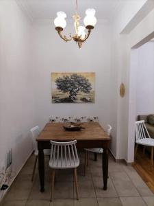 uma mesa de jantar com cadeiras e um lustre em Athens Apartment em Atenas