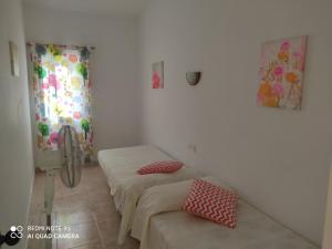 pokój z 2 łóżkami i krzesłem w obiekcie Menorca Cala Galdana w Cala Galdana
