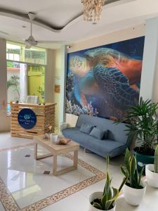 un salon orné d'une grande peinture de tortue dans l'établissement Reef Hostel Manta, à Manta