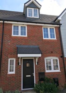 a red brick house with a black door at Smith's Loft in Chichester