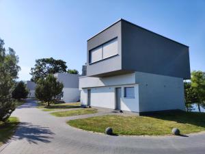 a black and white house with a driveway at Apartment Sloneczny Grodek 68 in Gródek Nad Dunajcem