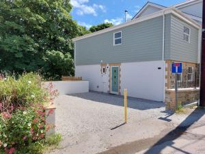 a garage with a white garage door and a building at Two bedroom cottage - country lane -10 min walk to Perranporth beach in Perranporth