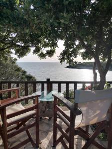 a table and chairs on a balcony with the ocean at Dionisis Apartments in Kounopetra