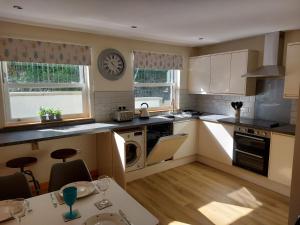 a kitchen with a table and a clock on the wall at Two bedroom cottage - country lane -10 min walk to Perranporth beach in Perranporth