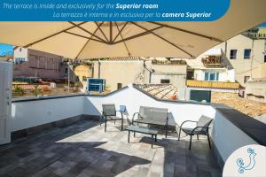 a patio with a table and chairs and an umbrella at Karú Suites in Cagliari