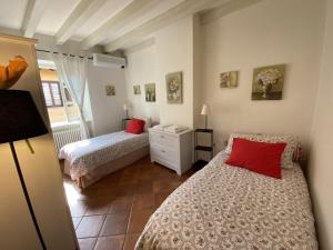 Un dormitorio con dos camas con almohadas rojas. en Casa del lago, en Menaggio