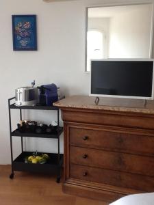 a living room with a dresser and a flat screen tv at B&B La Sergerie in Le Lavandou