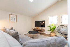 ein Wohnzimmer mit einem Sofa und einem TV in der Unterkunft Villa Doctores - Remise 08 in Heringsdorf