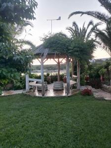 a gazebo with a bench in a yard at Dionisis Apartments in Kounopetra