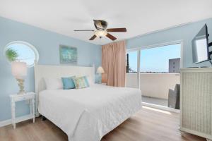 une chambre avec un lit et un ventilateur de plafond dans l'établissement Pelican Isle 301, à Fort Walton Beach 44 autres photos